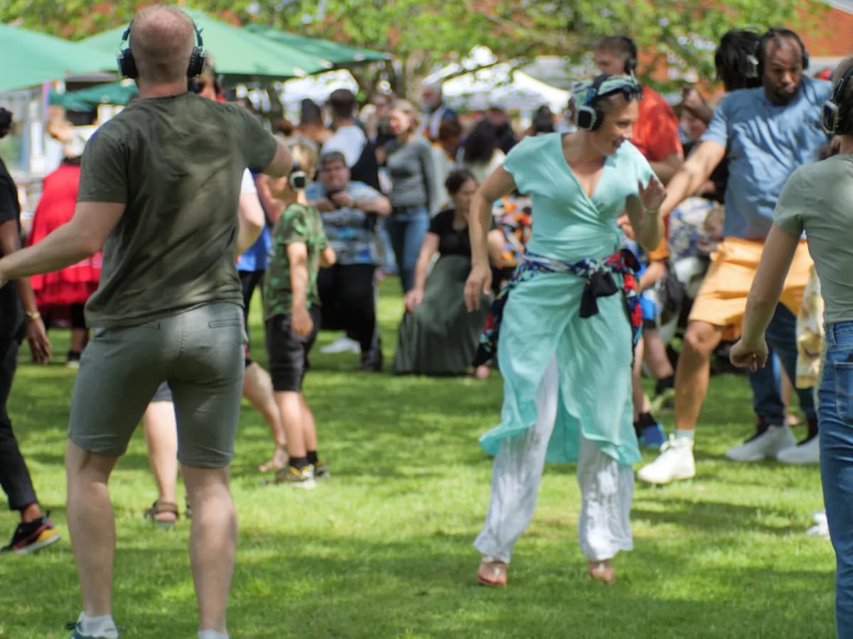 Deltagere danser sammen i en lys sal